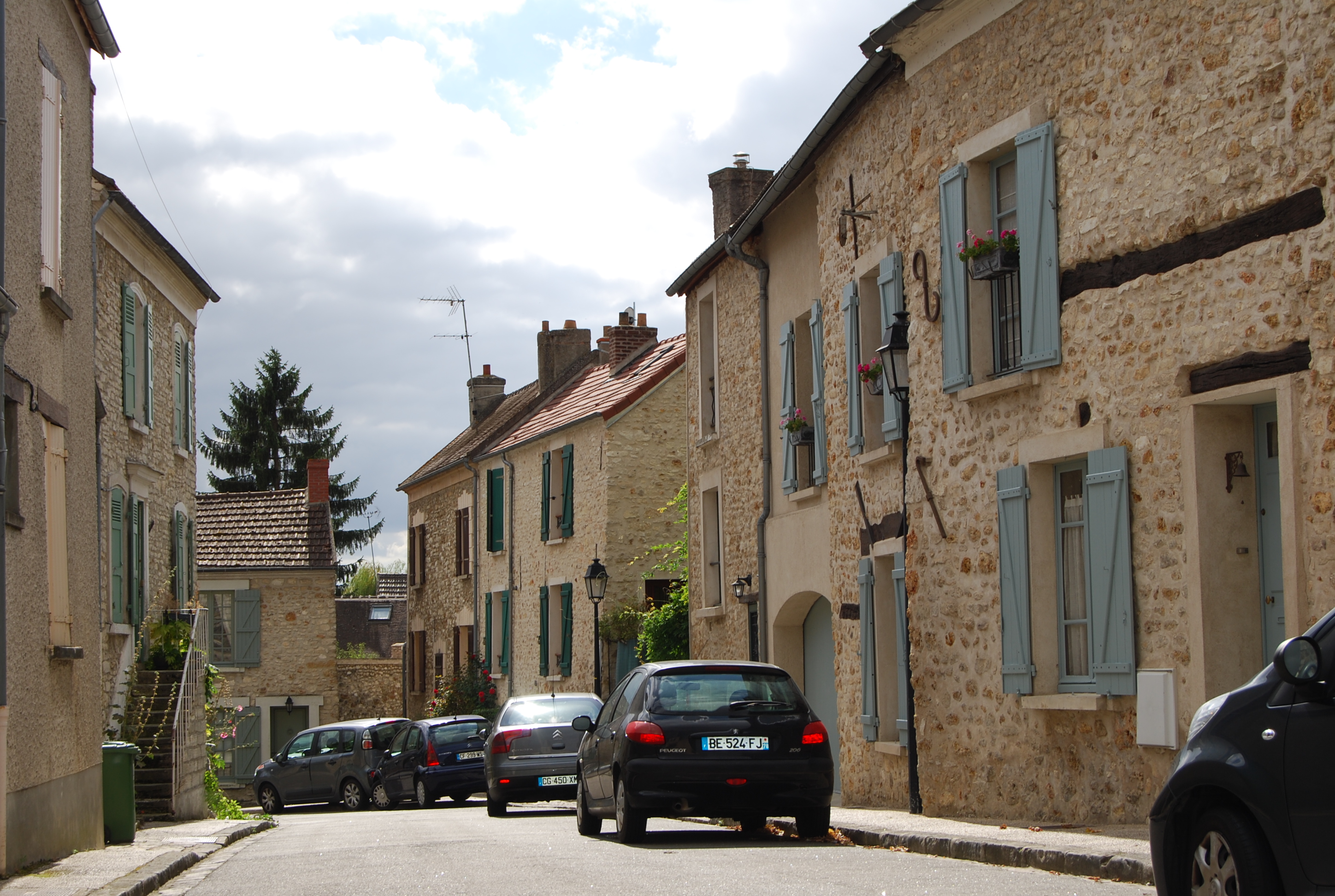 Une rue de village à Crespières, qui témoigne de la rénovation du patrimoine architectural des villages des Yvelines : qualité du paysage bâti traditionnel requalifié, maîtrise qualitative des enduits de façade, harmonie des couleurs d’huisserie…