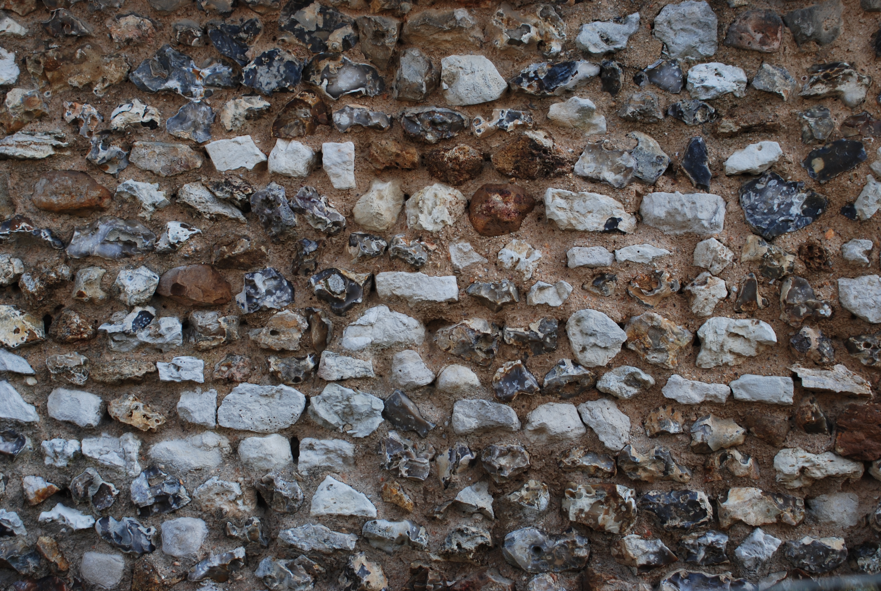 Silex et craie dans un mur de la Villeneuve-en-Chevrie, qui rappellent la liaison du plateau à la Normandie et à la vallée de la Seine crétacée